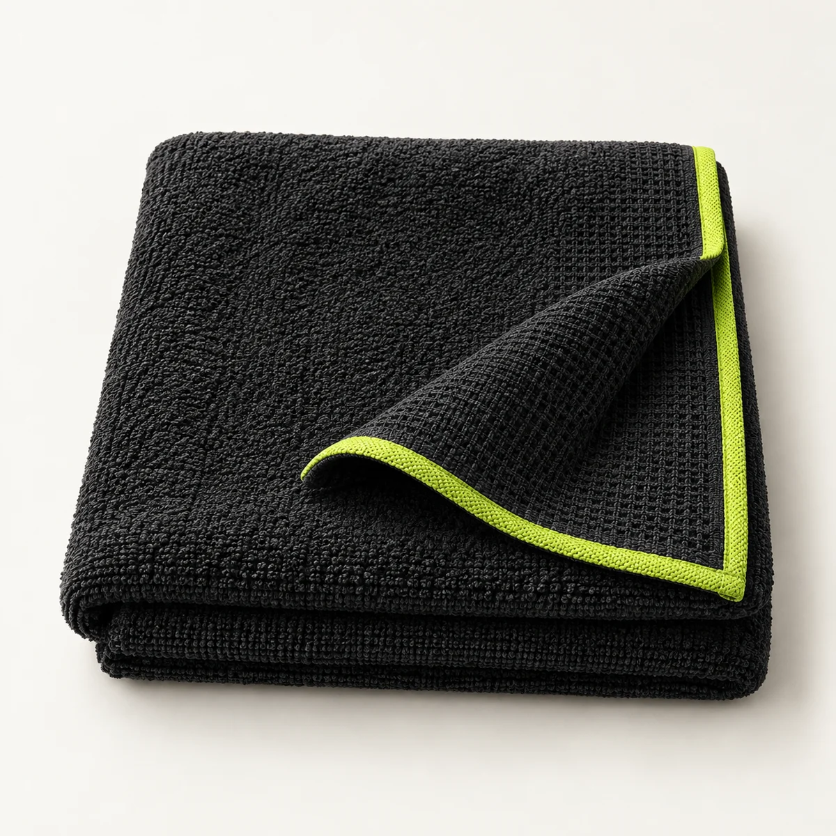Concept rendering of a folded charcoal court towel with lime edging; final fabric and design may differ.